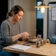 Woman measuring dried mushrooms with scale in kitchen