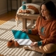 Woman writing trip preparation checklist at home