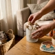 Hands storing dried psilocybin mushrooms in airtight jar